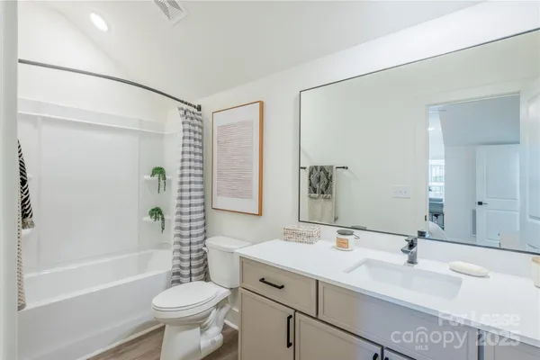 a bathroom with a sink toilet a mirror and shower