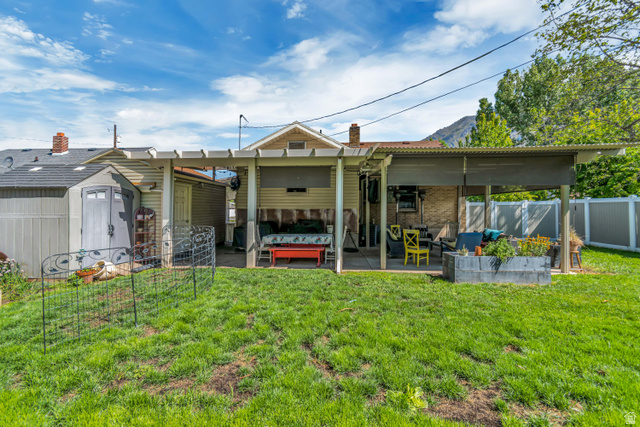 127 West 300 North Springville, UT 84663 - Photo 24 of 24 Expansive backyard featuring a covered patio, a separate storage shed, a pergola-style structure, and a wood-slat privacy fence
