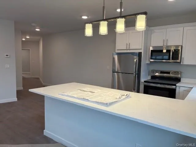 a kitchen with stainless steel appliances a refrigerator sink and microwave