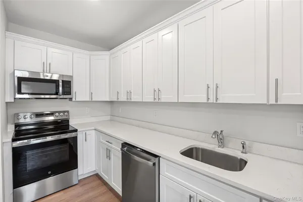 a kitchen with white cabinets and stainless steel appliances