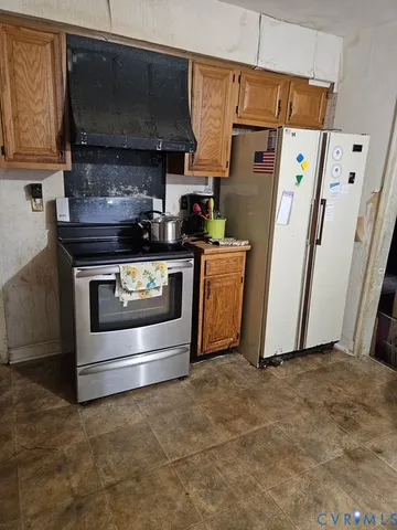 a kitchen with stainless steel appliances a stove a refrigerator a sink a stove and cabinets