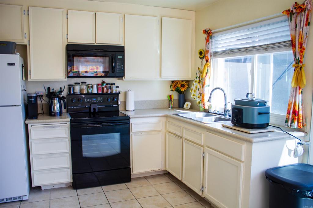 10385 Seth Way Santee, CA 92071 - Photo 8 of 33 a kitchen with white cabinets and appliances
