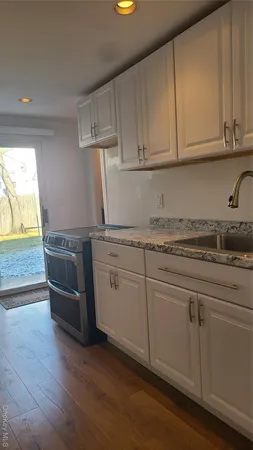 a kitchen with granite countertop white cabinets and white appliances