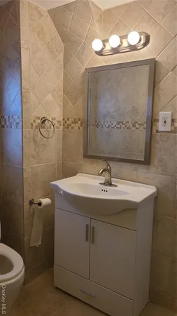 a bathroom with a sink and mirror with toilet