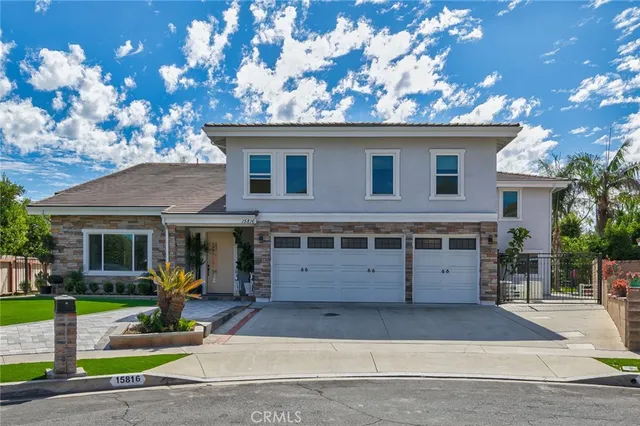 a view of a white house with large windows and a large tree