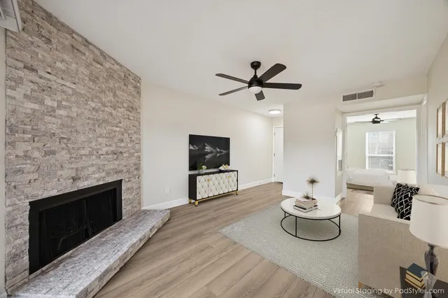 a living room with furniture a flat screen tv and a fireplace