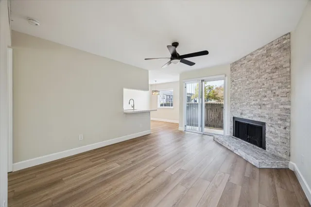 a view of empty room with wooden floor and fireplace