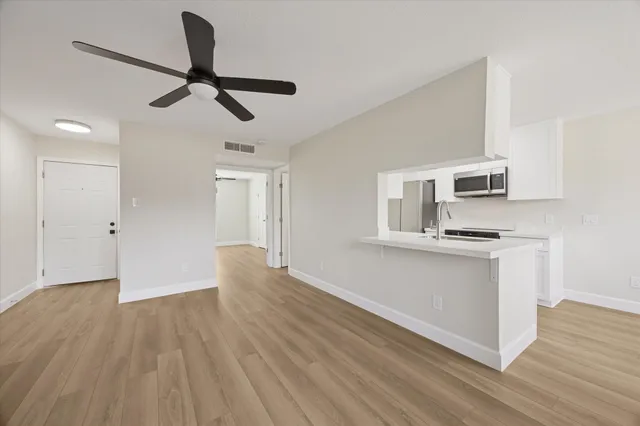 a view of empty room with wooden floor and window