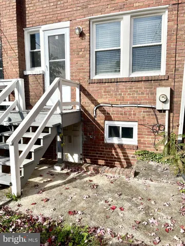 a view of a brick house with large windows and a tree