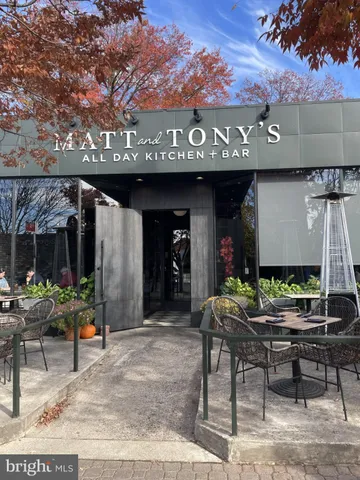 a view of a building with a space and a car parked on the road