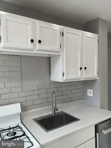 a kitchen with white cabinets and a sink
