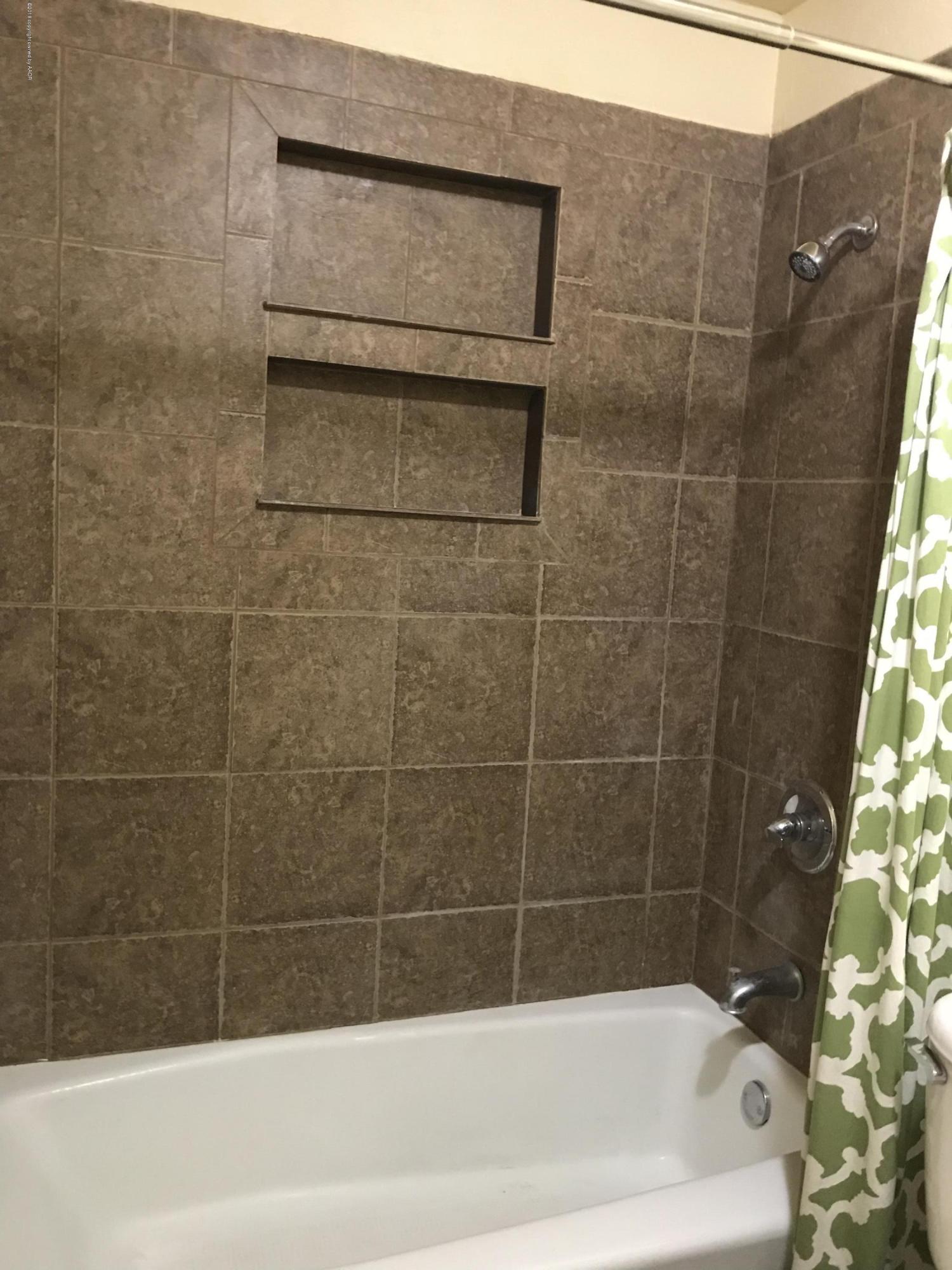 4632 Cline Road Amarillo, TX 79110 - Photo 11 of 27 a bathroom with a bathtub and shower