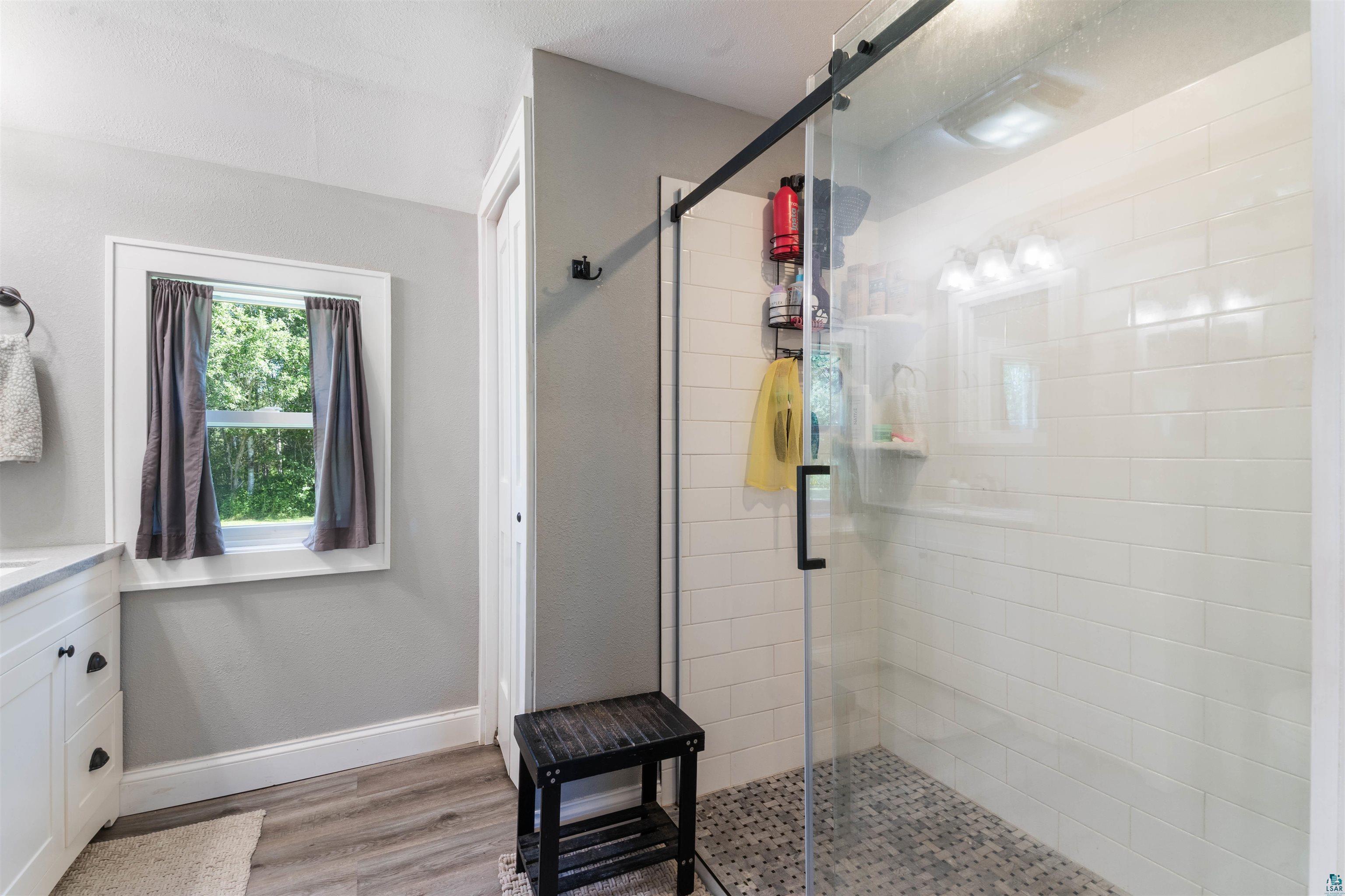 3835 South County Rd K South Range, WI 54874 - Photo 6 of 29 Glass-enclosed shower featuring subway tile surround and mosaic tile flooring