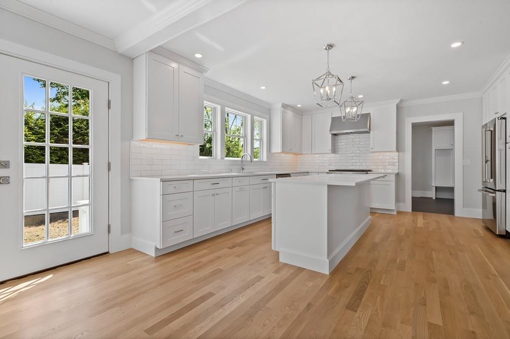 36 Bulow Road Hingham, MA 02043 - Photo 4 of 40 a large kitchen with stainless steel appliances granite countertop a stove a sink dishwasher a refrigerator and white cabinets with wooden floor