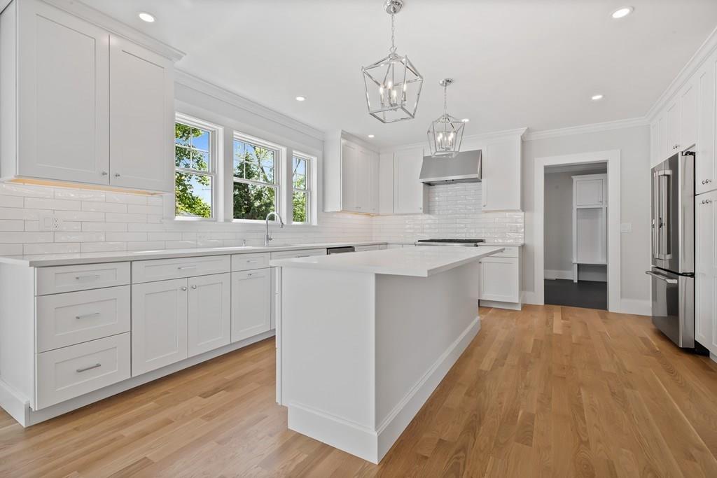 36 Bulow Road Hingham, MA 02043 - Photo 9 of 40 a kitchen with stainless steel appliances kitchen island granite countertop a sink cabinets and wooden floor