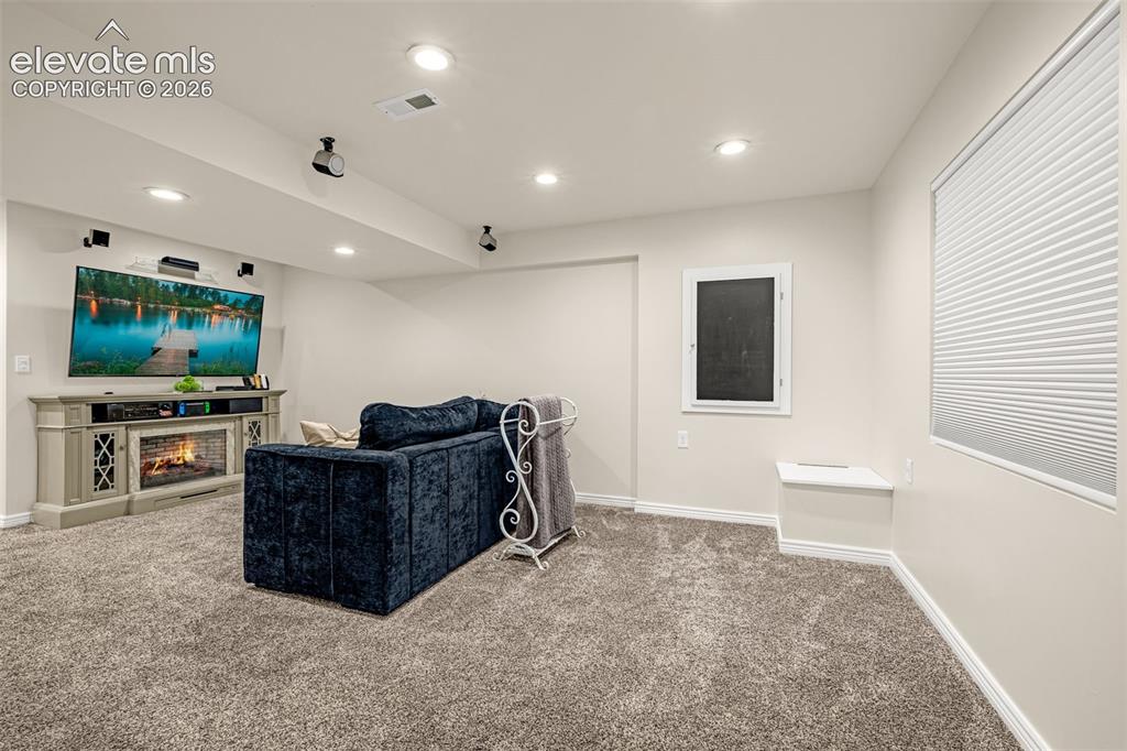 9127 Oakmont Road Peyton, CO 80831 - Photo 32 of 49 a living room with furniture and a flat screen tv