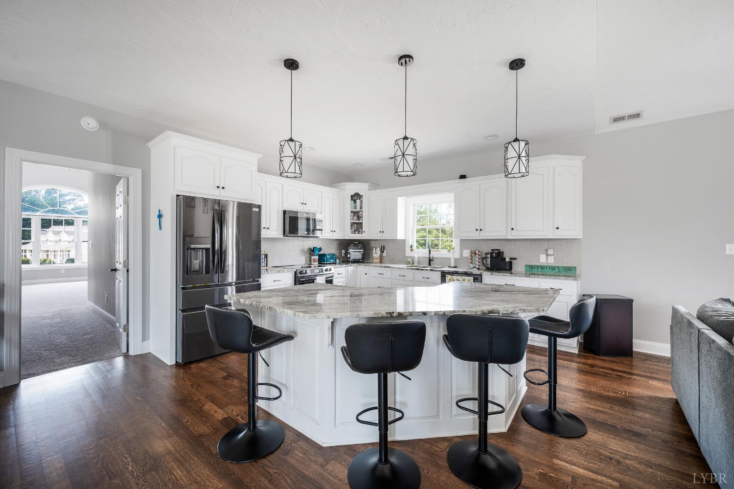 101 Little Creek Road Moneta, VA 24121 - Photo 28 of 76 a kitchen with stainless steel appliances kitchen island granite countertop a refrigerator a stove a sink dishwasher and white cabinets with wooden floor
