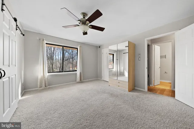a view of a livingroom with a ceiling fan and windows