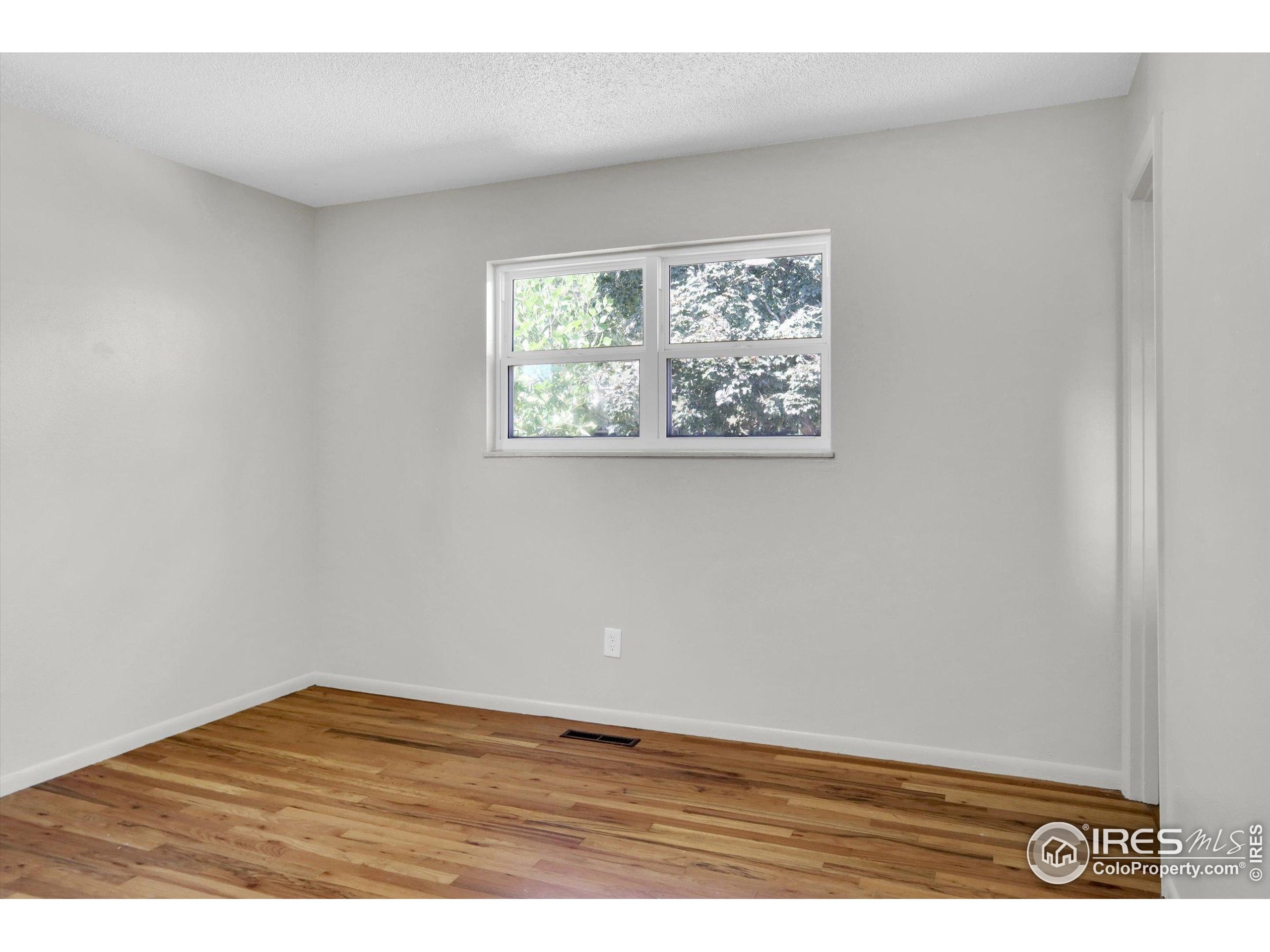 4630 Macky Way Boulder, CO 80305 - Photo 19 of 40 an empty room with wooden floor and painting on the wall