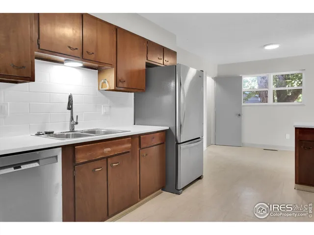 a kitchen with stainless steel appliances granite countertop a refrigerator a sink and a stove