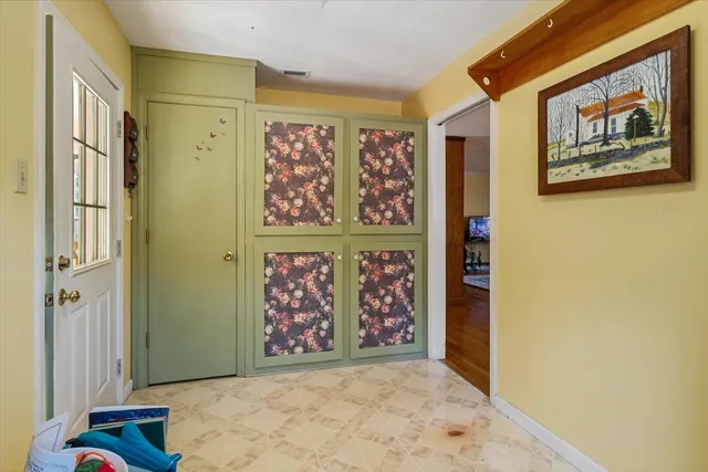 a view of a hallway with windows and chandelier