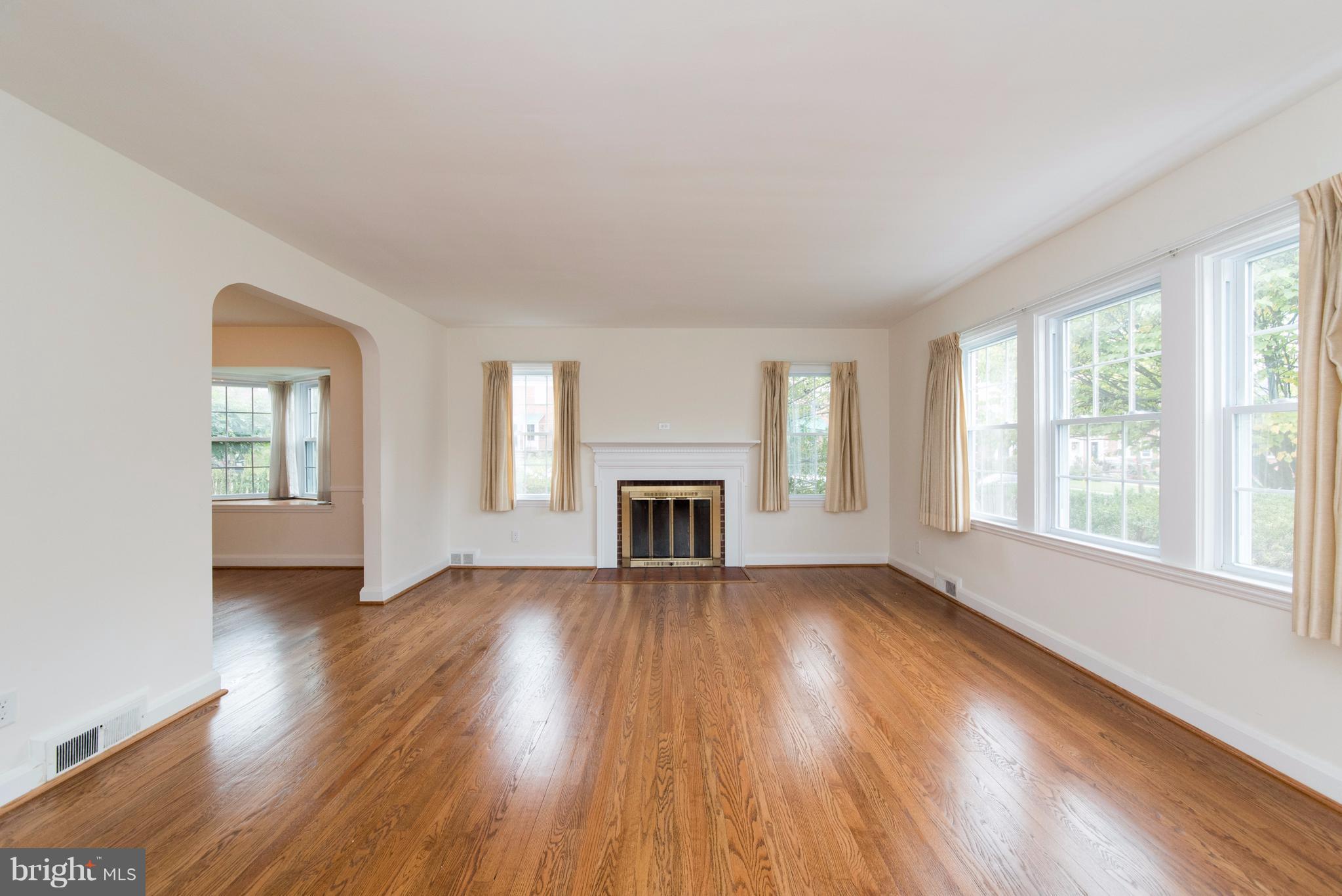 1906 Glen Ridge Road Towson, MD 21286 - Photo 5 of 30 an empty room with wooden floor fireplace and windows