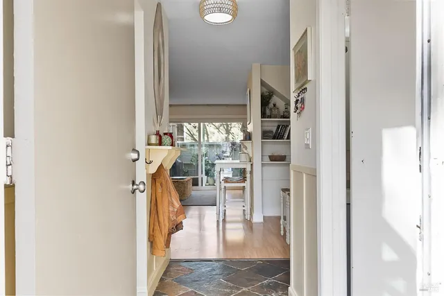 a view of a hallway with wooden floor and a living room