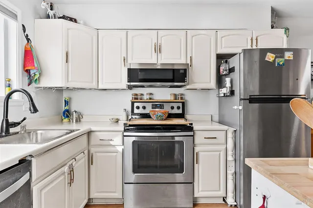 a kitchen with appliances a sink and cabinets
