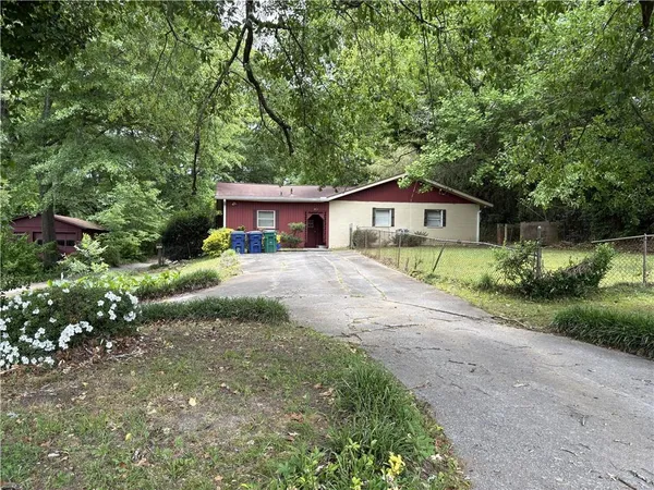 a front view of a house with a yard and green space