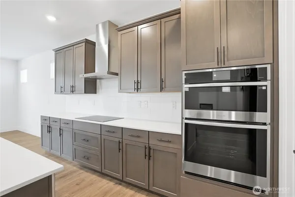 a kitchen with stainless steel appliances cabinets and wooden floor
