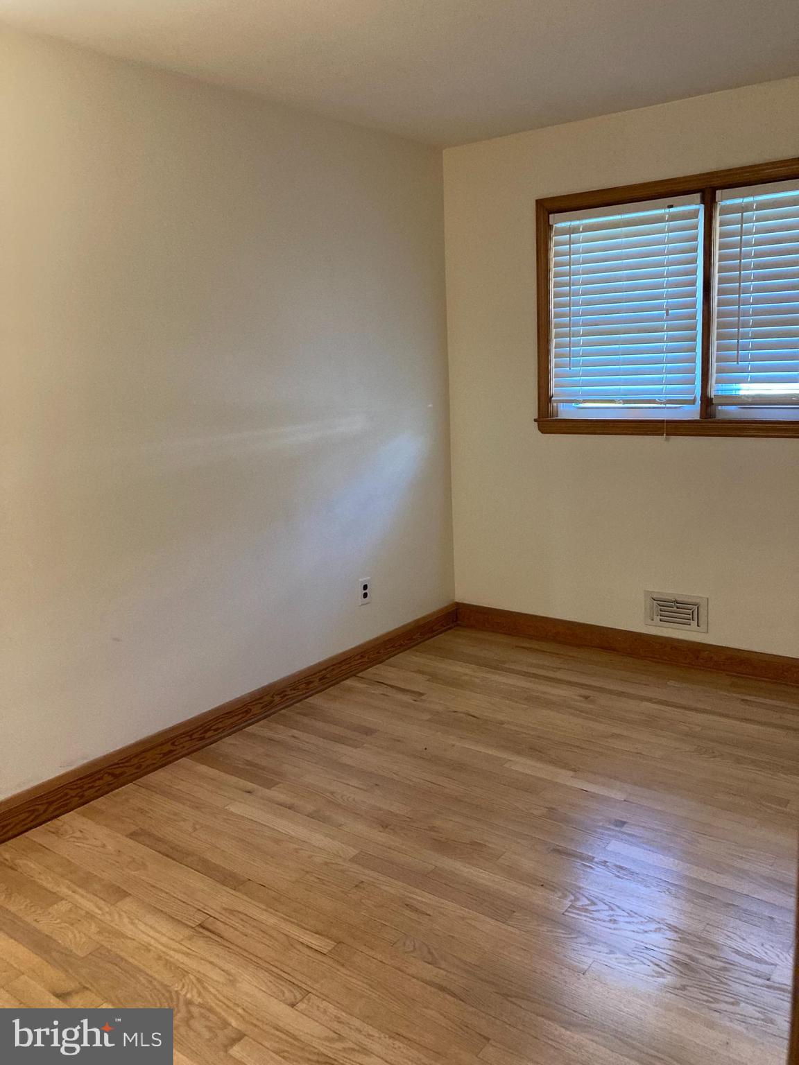 1713 Cape May Road Baltimore, MD 21221 - Photo 18 of 34 a view of an empty room with wooden floor and a window