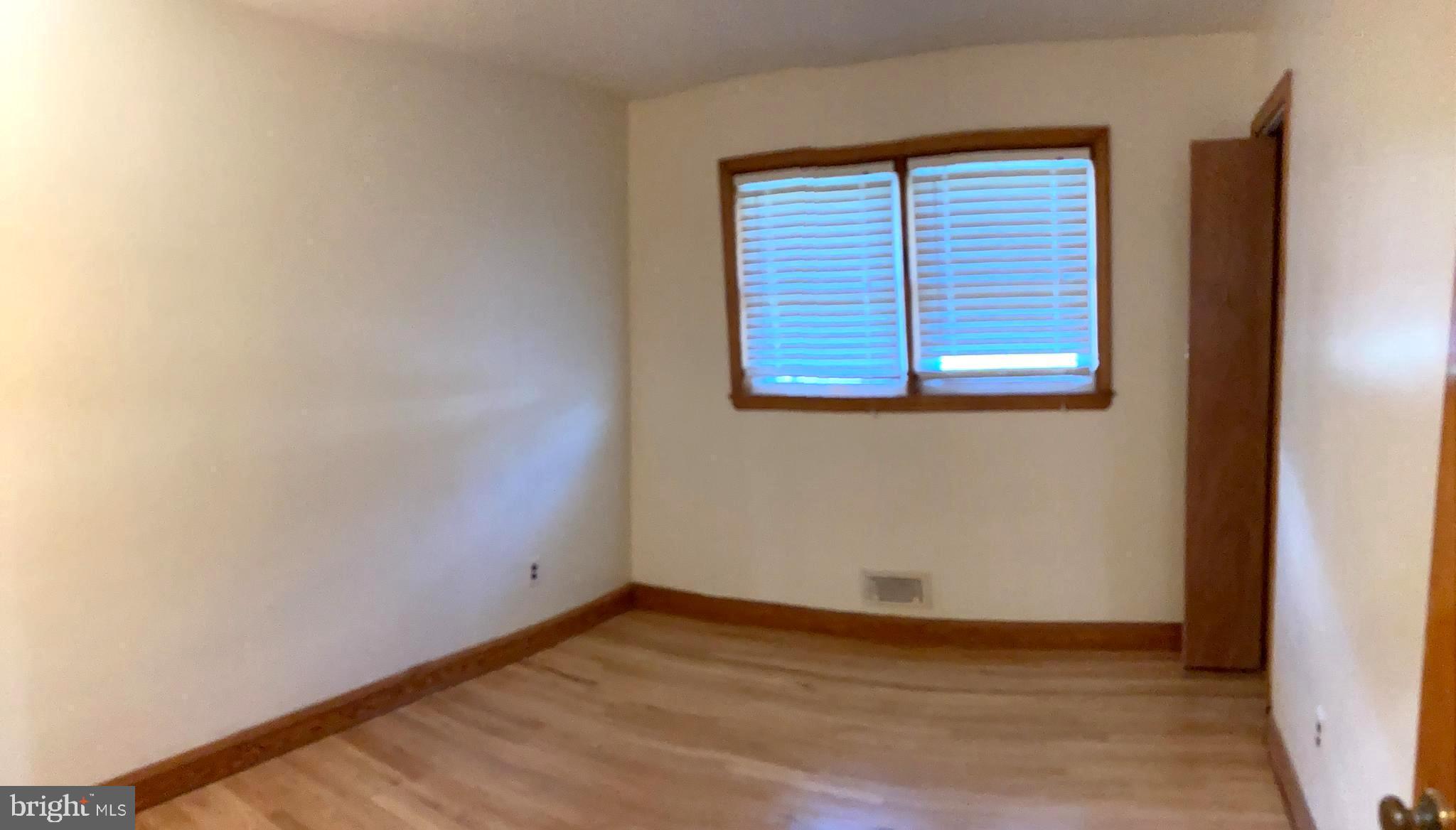 1713 Cape May Road Baltimore, MD 21221 - Photo 19 of 34 a view of an empty room with wooden floor and a window