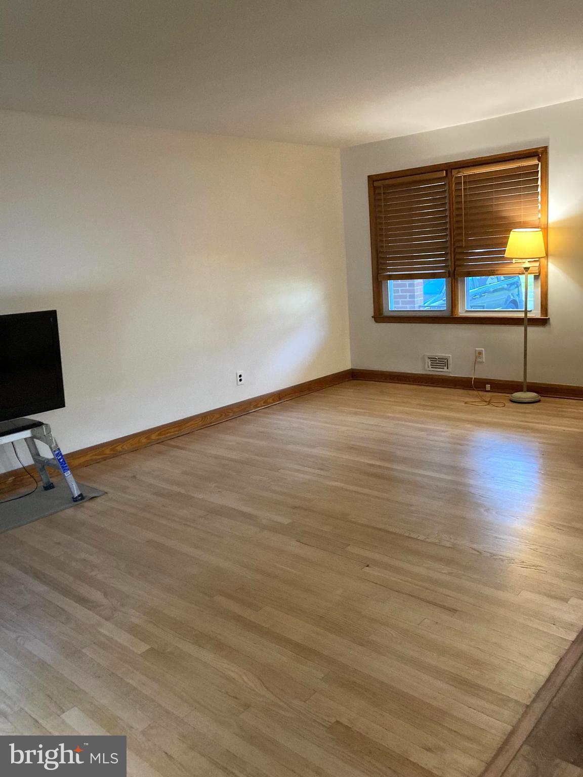 1713 Cape May Road Baltimore, MD 21221 - Photo 9 of 34 a view of an empty room with wooden floor and a window