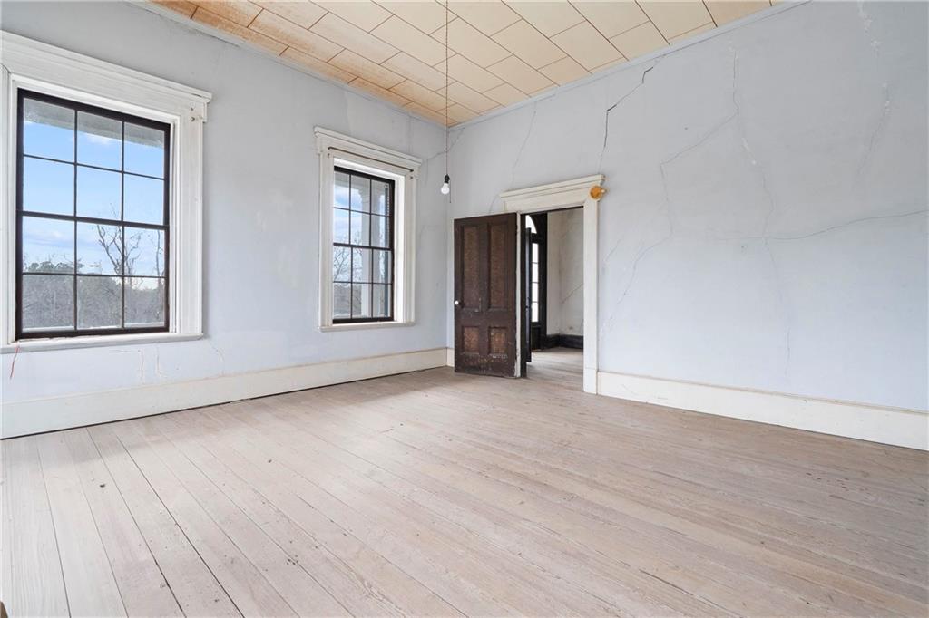 12871 Linton Road Sparta, GA 31087 - Photo 15 of 56 a view of an empty room with a window and wooden floor