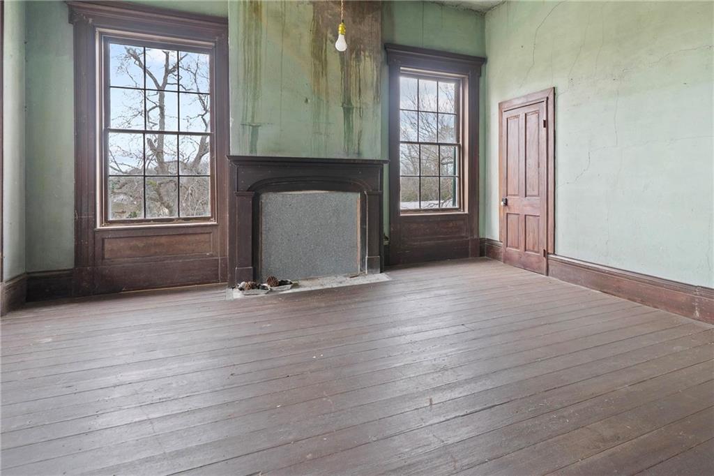 12871 Linton Road Sparta, GA 31087 - Photo 18 of 56 an empty room with wooden floor and a fireplace