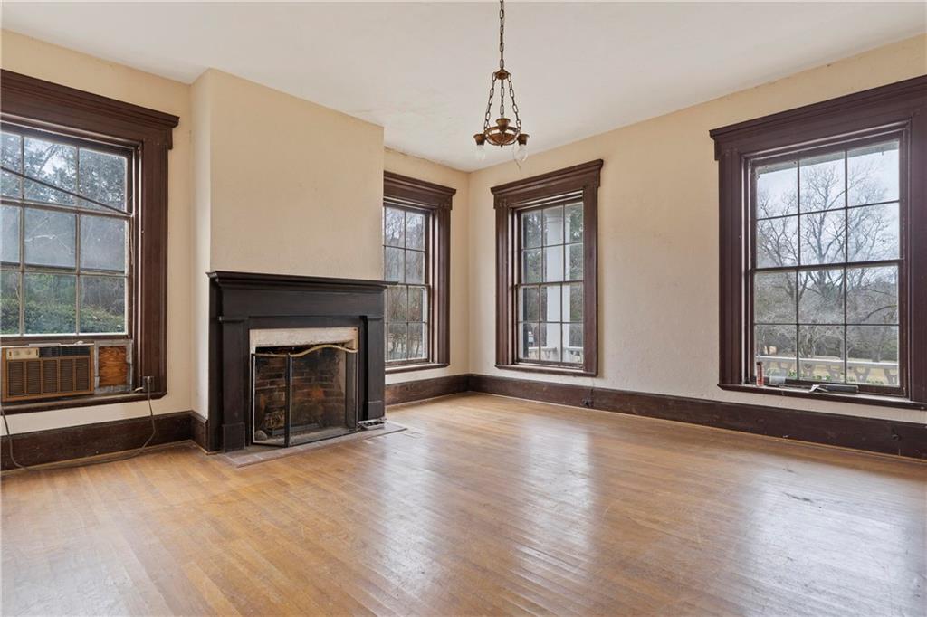 12871 Linton Road Sparta, GA 31087 - Photo 45 of 56 a view of an empty room with wooden floor fireplace and a window
