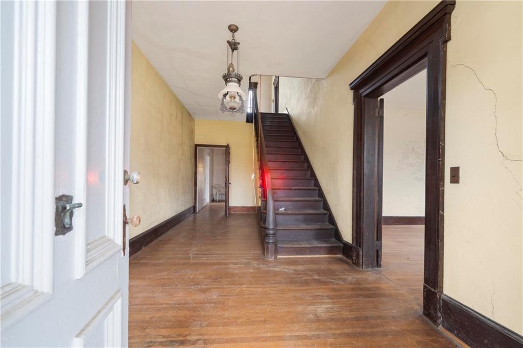 12871 Linton Road Sparta, GA 31087 - Photo 48 of 56 a view of a hallway with wooden floor and staircase