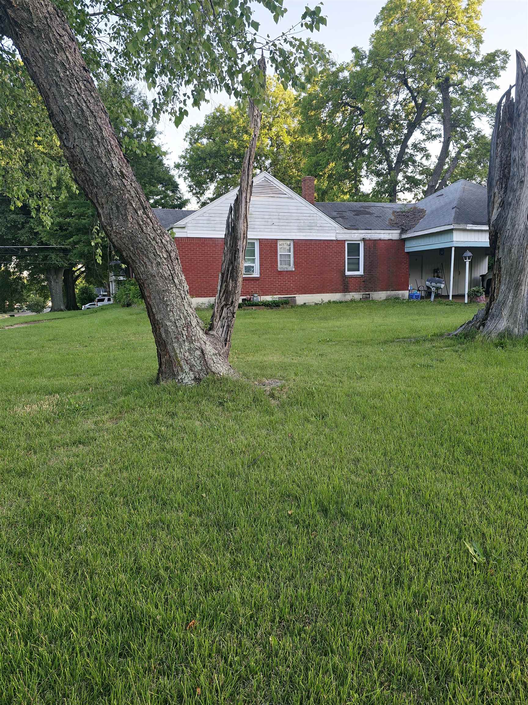 1515 Semmes Street Memphis, TN 38114 - Photo 5 of 9 Expansive green lawn surrounds a brick and siding residence with a covered porch