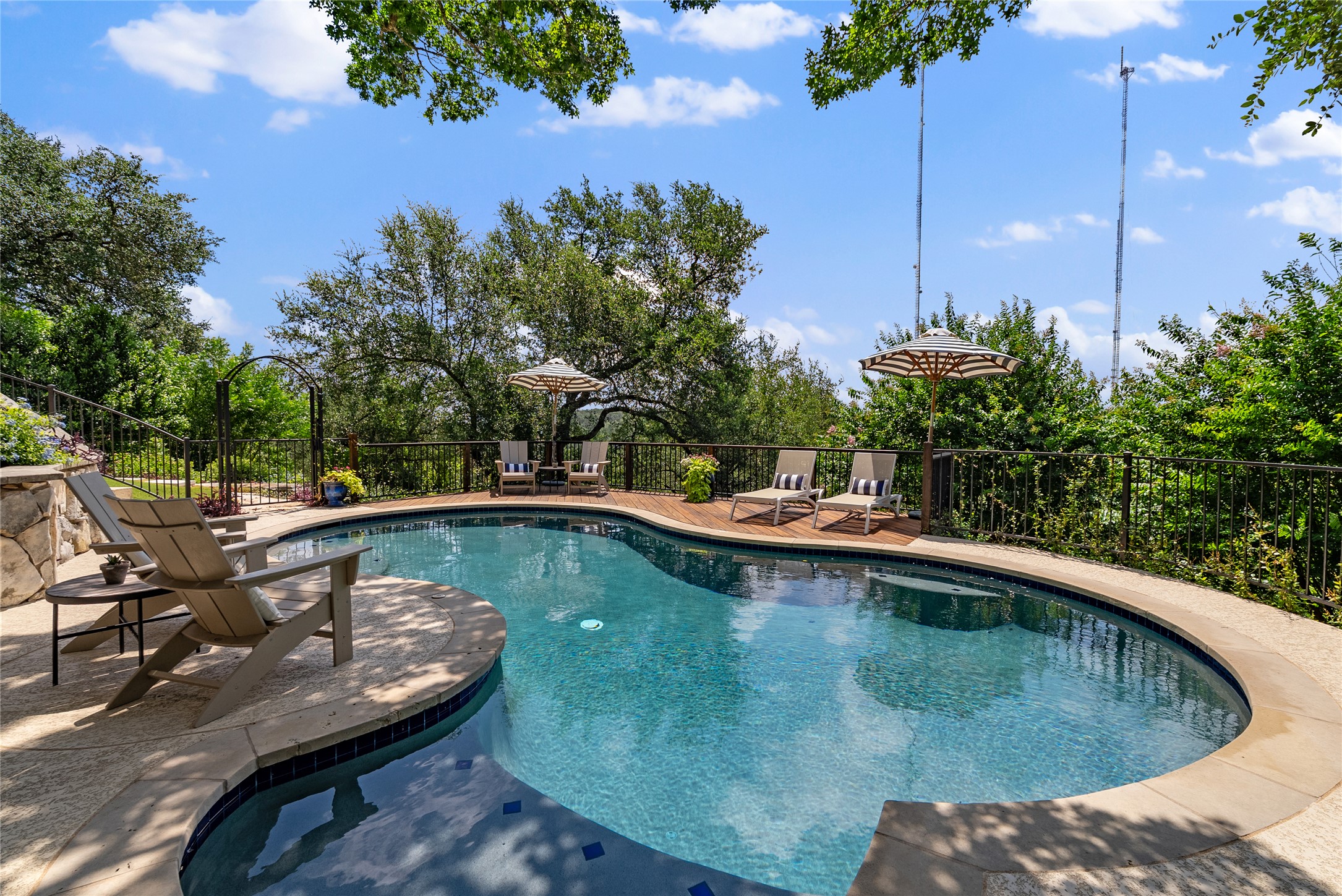 3107 Lookout Lane Austin, TX 78746 - Photo 7 of 39 An inviting private pool and deck are surrounded by lush greenery, perfect for relaxation and outdoor enjoyment.