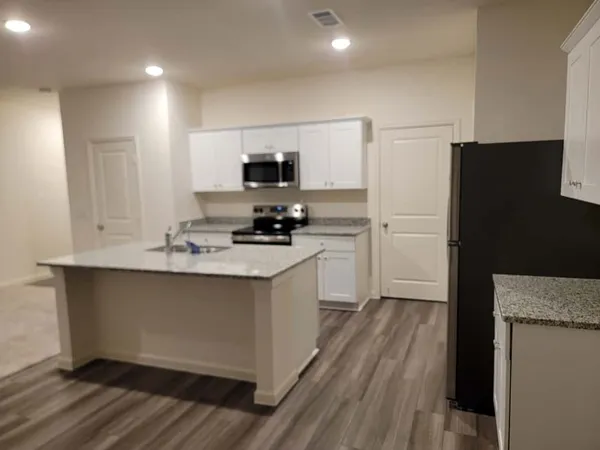 a kitchen with a refrigerator and a stove top oven