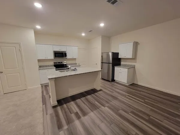 a kitchen with stainless steel appliances a refrigerator and a stove top oven