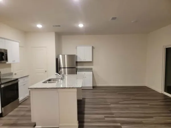 a kitchen with kitchen island a sink appliances and cabinets