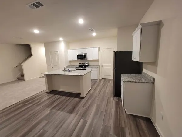 a large kitchen with a sink stainless steel appliances and cabinets
