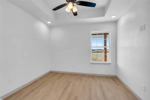 an empty room with a window and a ceiling fan