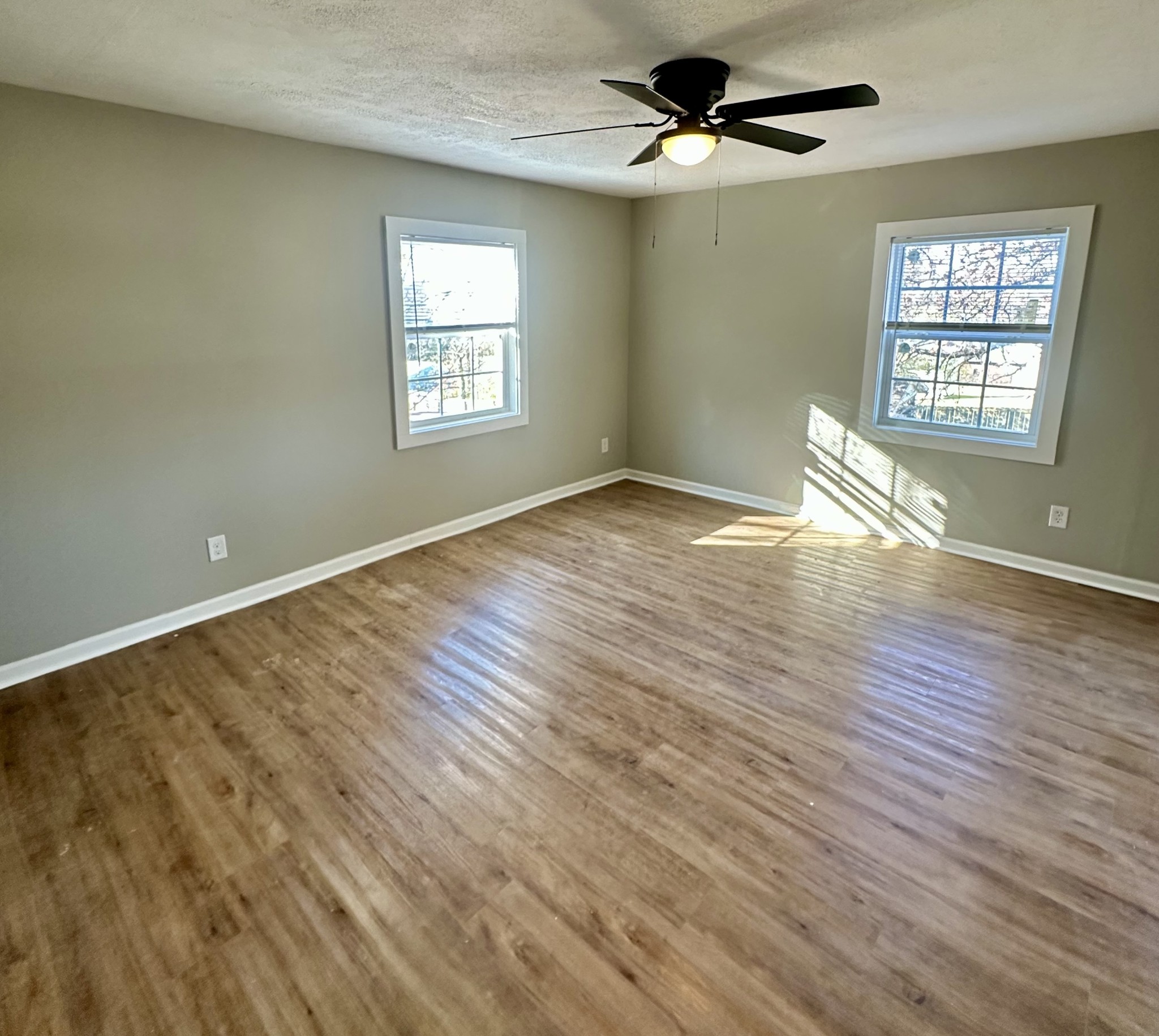 507 Spring Street East Cookeville, TN 38501 - Photo 7 of 15 an empty room with wooden floor ceiling fan and windows