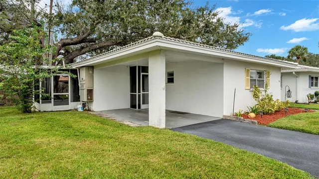 front view of a house with a yard and potted plants