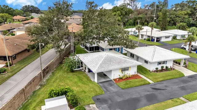 an aerial view of a house with swimming pool and large trees