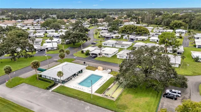 an aerial view of residential houses with outdoor space and trees