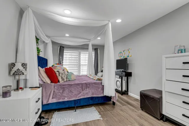 a bedroom with a bed wooden floor and window