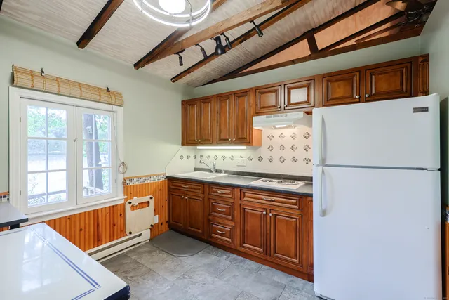 a kitchen with stainless steel appliances granite countertop a refrigerator a sink dishwasher a stove and a refrigerator with wooden cabinets